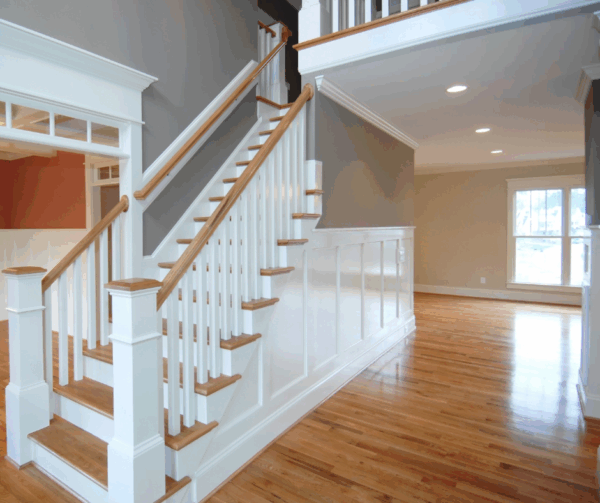 A beautifully designed interior showcasing white stair railings and hardwood floors in a spacious living area.