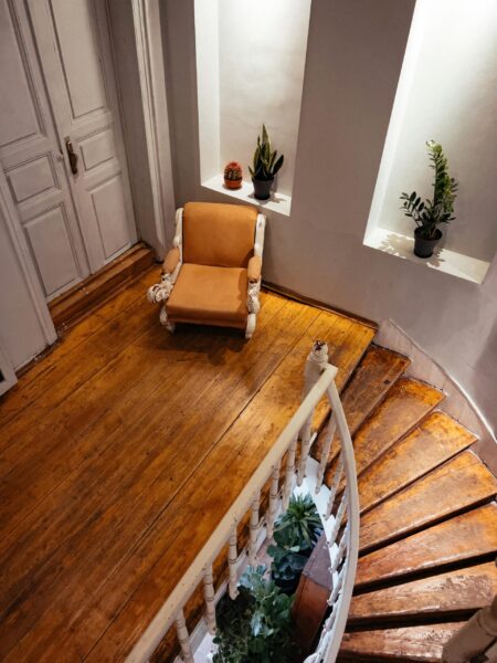 A stylish interior featuring a brown armchair and elegant spiral staircase